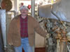 A volunteer stands next to the Cooper - Bessemer 900 HP diesel main engine in LV-112's engine room.